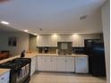 Bright kitchen with white cabinets, modern appliances, tile floor, and plenty of counter space at 325 N Causeway # D104, New Smyrna Beach, FL 32169