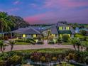 Two-story home boasting lush landscaping, circular driveway, an inviting entryway with elegant exterior lighting at 4301 Down Point Ln, Windermere, FL 34786