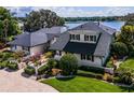 Two-story home boasting lush landscaping, a circular driveway, and a beautiful waterside view at 4301 Down Point Ln, Windermere, FL 34786