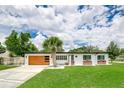 Charming home with a modern garage door, lush lawn, and flower boxes enhancing its curb appeal at 532 Darcey Dr, Winter Park, FL 32792