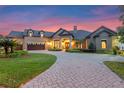 Beautiful home with a paver driveway and manicured landscaping, seen at twilight at 5640 Brookline Dr, Orlando, FL 32819