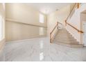 Bright living room with a soaring ceiling, a staircase, and gorgeous marble floors at 5803 Cheshire Cove Ter, Orlando, FL 32829