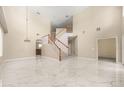 Spacious living room featuring a staircase, a soaring ceiling and sleek marble floors at 5803 Cheshire Cove Ter, Orlando, FL 32829