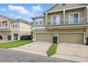 Townhome featuring a two-car garage with a well-maintained lawn at 7130 Forty Banks Rd, Harmony, FL 34773
