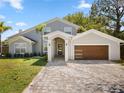 Beautiful single-Gathering home featuring modern architecture, a well-manicured lawn, and a brick-paved driveway at 8616 Port Said St, Orlando, FL 32817