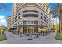 Exterior view of a luxury building with outdoor seating and a restaurant on the ground floor at 100 S Eola Dr # 1102, Orlando, FL 32801
