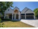 Eye-catching modern home featuring a white exterior, glass garage door, and stylish front yard at 1220 Delaney Park Dr, Orlando, FL 32806