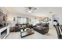 Bright living room boasts modern decor, including two comfortable grey sofas and a decorative ceiling fan at 1423 Marsh Meadow Ln, Davenport, FL 33896