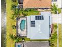 Aerial view of home featuring a screened in pool, solar panels, and a lake view at 1712 Boat Launch Rd, Kissimmee, FL 34746