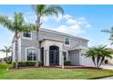 Charming two-story home with a well manicured lawn featuring palm trees and decorative landscaping at 1712 Boat Launch Rd, Kissimmee, FL 34746