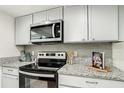 Kitchen featuring stainless steel microwave and range with granite countertops at 1826 Warringwood Dr # B-1, Orlando, FL 32839