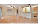 Open-concept living room featuring wood floors, neutral paint and seamless flow to kitchen at 190 Hickory Woods Ct # 12B, Deltona, FL 32725