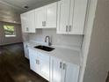 Updated kitchen featuring bright white cabinets, modern countertops, and stylish fixtures, enhanced by durable wood-look flooring at 1921 Nw 12Th St, Ocala, FL 34475