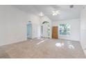 Bright living room featuring soaring ceiling, neutral carpet and paint, ceiling fan, and ample natural light at 205 Lori Ct, Umatilla, FL 32784