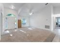 Bright living room featuring soaring ceiling, neutral carpet and paint, ceiling fan, and ample natural light at 205 Lori Ct, Umatilla, FL 32784
