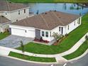 Aerial view of home with three-car garage, landscaping, and a pond nearby at 2152 Rock Maple Bnd, Kissimmee, FL 34746