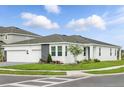 Beautiful home exterior features manicured lawn, lush landscaping, and a convenient three-car garage at 2152 Rock Maple Bnd, Kissimmee, FL 34746