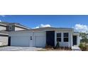 Charming single-story home featuring a clean white facade, stone accents, and a spacious three-car garage at 2152 Rock Maple Bnd, Kissimmee, FL 34746