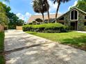 Exterior view of a home with a spacious driveway and well-maintained landscaping at 2155 Palm View Dr, Apopka, FL 32712