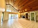 Spacious living room with vaulted ceilings, tile flooring, and a stone fireplace at 2155 Palm View Dr, Apopka, FL 32712