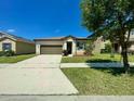 Single-story home featuring a lawn, a driveway, and an attached two-car garage at 254 Alford Dr, Davenport, FL 33896