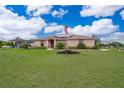 Charming single-story home with a lush green lawn, front garden, and flagpole with an American flag at 2602 Adelia Blvd, Deltona, FL 32725