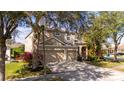 Charming tan two-story home with a two car garage and mature landscaping near a streetlight at 2602 Shirehall Ln, Winter Garden, FL 34787