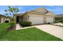 Inviting home featuring a well-maintained lawn, a two-car garage, and attractive landscaping at 2936 Sunridge Loop, St Cloud, FL 34771