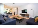 Open-concept living room flows into the kitchen and features modern furniture and a large-screen TV at 3042 Herold Dr, Orlando, FL 32805
