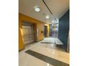 Hallway with stainless steel elevators and modern lighting at 322 E Central Blvd # 908, Orlando, FL 32801