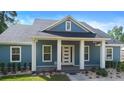 Inviting blue home with a covered front porch and white trim, creating a welcoming entrance at 34 Jackson Cir, Winter Springs, FL 32708