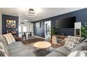 Stylish living room with blue accent wall, modern lighting, comfortable gray sofas and an open bar area at 3511 E Crystal Lake Ave, Orlando, FL 32806