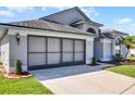 View of the property's two car garage, lawn and partial view of the home at 7606 Fordham Creek Ln, Orlando, FL 32818