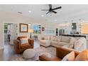 Open-concept living room with large windows, comfortable sectional, and access to the kitchen at 8003 Lake Nellie Rd, Clermont, FL 34714