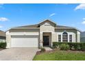 Charming single-story home featuring a well-manicured lawn, brick driveway, and a two-car garage at 838 Kildrummy Dr, Davenport, FL 33896