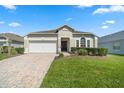Charming single-story home featuring a well-manicured lawn, brick driveway, and a two-car garage at 838 Kildrummy Dr, Davenport, FL 33896