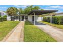 Inviting home exterior featuring a manicured lawn and a covered carport with a paved driveway at 843 W Swoope Ave, Winter Park, FL 32789