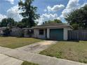 Single-Gathering home boasts a one-car garage and a quaint front yard with lush landscaping at 871 Darwin Dr, Altamonte Springs, FL 32701