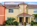 Charming townhome with a red tile roof, well-maintained landscaping, and inviting double front doors at 8971 California Palm Rd, Kissimmee, FL 34747