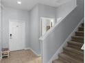 Light-filled foyer with tile flooring, stairs, and white front door at 8971 California Palm Rd, Kissimmee, FL 34747