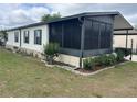A view of the home's exterior, showing a screened-in porch and tidy landscaping at 117 Darlene Ct, Davenport, FL 33897