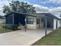 Well-maintained exterior with a carport, landscaped yard, and a charming screened-in porch at 117 Darlene Ct, Davenport, FL 33897