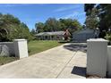 Long driveway leading to a charming one-story home and detached two-car garage on a sunny day at 12015 Se 72Nd Court Rd, Belleview, FL 34420
