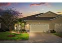 Charming single-story home with a well-maintained lawn and a two-car garage at dusk at 122 Lower Lake Ct, Debary, FL 32713