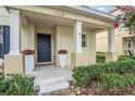 Inviting front entrance with elegant columns, decorative planters, and a secure, dark-colored door at 13118 Honey Locust Dr, Orlando, FL 32828