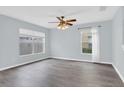 Spacious living room with modern gray floors, a ceiling fan, and ample natural light from the windows at 13118 Honey Locust Dr, Orlando, FL 32828