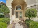 Elegant front entrance with double doors, an arched transom window, and meticulously maintained greenery at 13139 Paloma Dr, Orlando, FL 32837