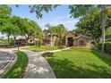 Beautiful two-story house boasts a manicured lawn, mature trees, and inviting curb appeal at 1544 Hunters Mill Pl, Oviedo, FL 32765
