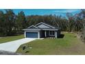 Charming single-story home featuring a blue garage door and a well-maintained lawn at 160 Fisher Loop, Ocklawaha, FL 32179