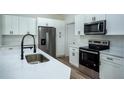 Close up of Kitchen featuring white cabinets, stainless steel appliances, and black fixtures at 160 Fisher Loop, Ocklawaha, FL 32179